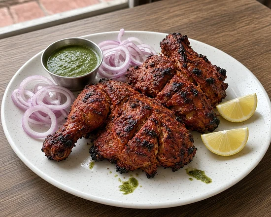 Tandoori chicken with onion rings, lemon and green chutney